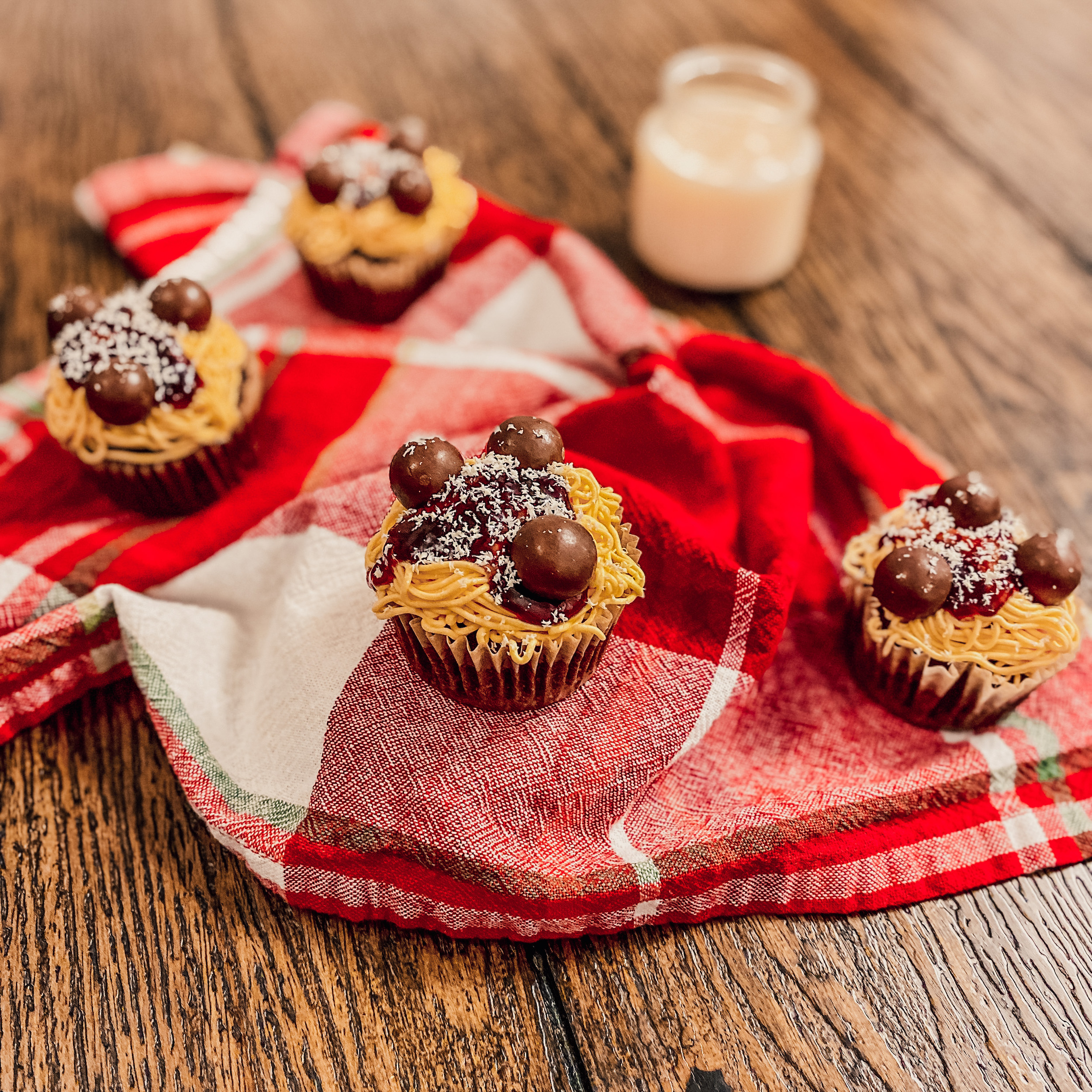 spaghetti cupcakes with candy meatballs on a plaid napkin