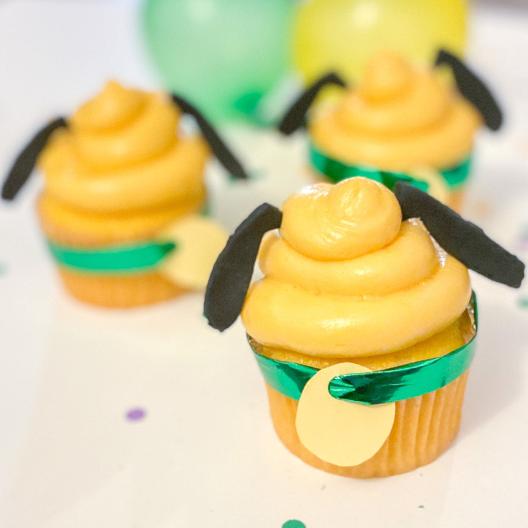 yellow pluto cupcake with fondant ears and yellow frosting