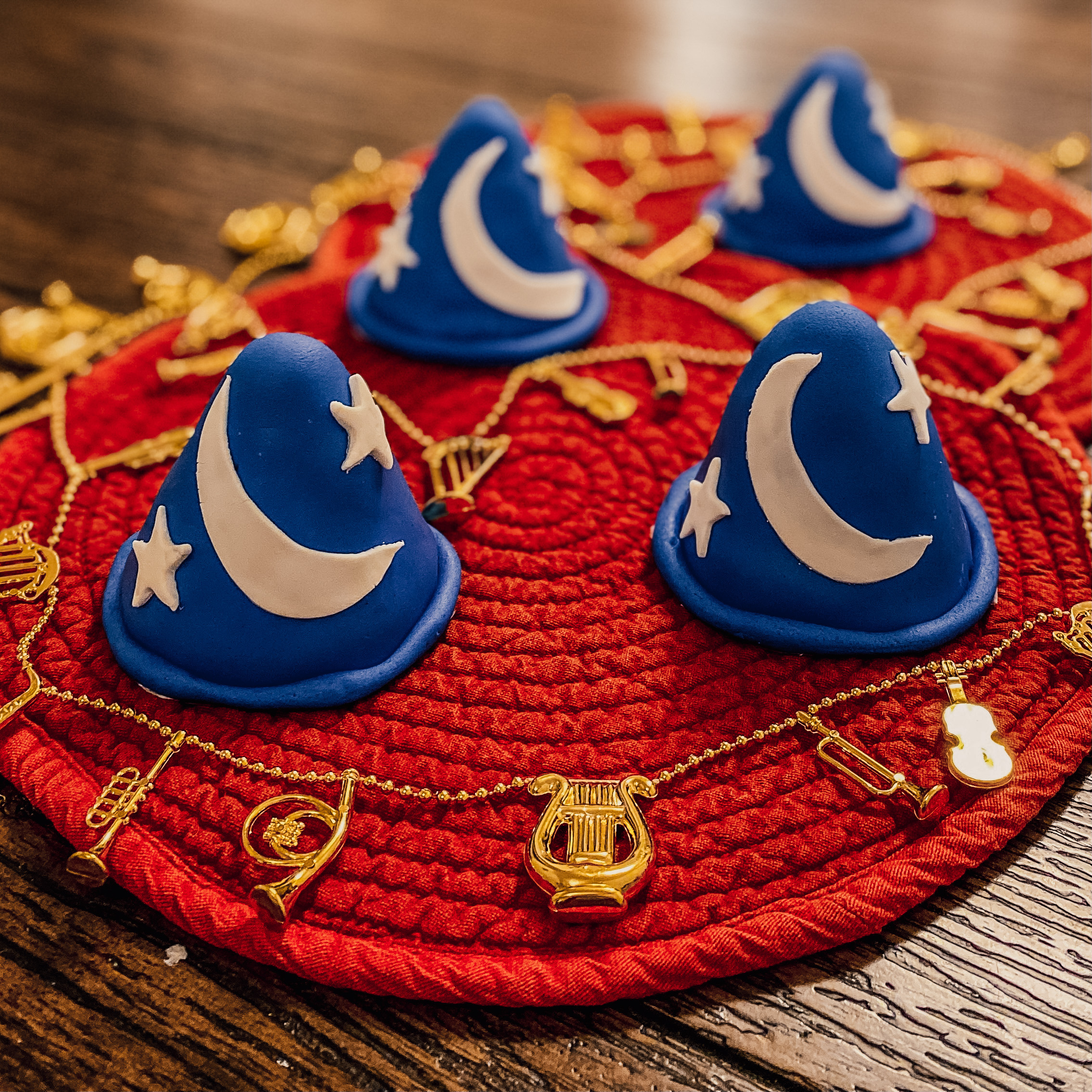 sorcerer mickey's hat cakes on a red background with gold musical instruments