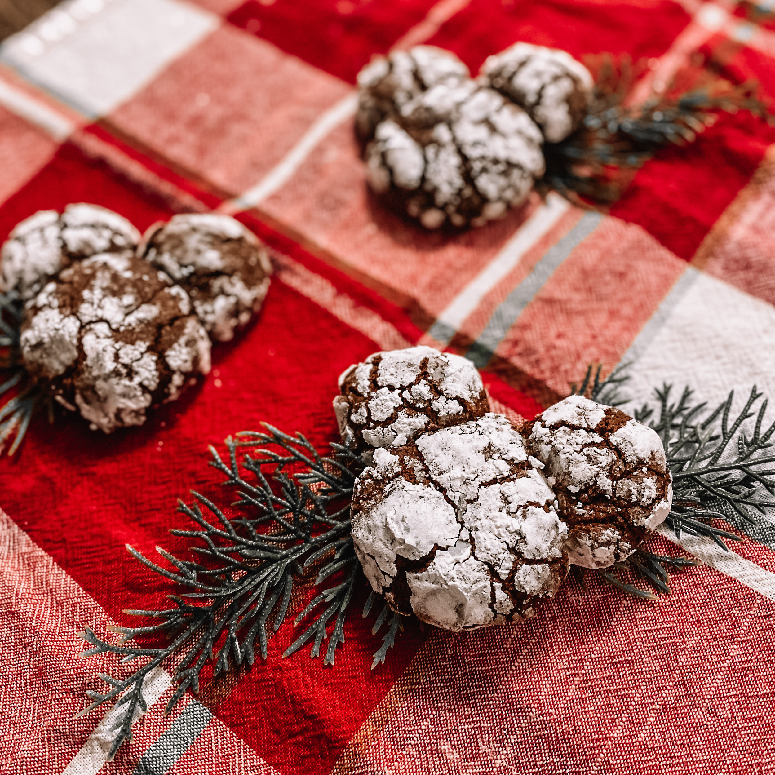 three chocolate mickey crinkle cookies on a red cloth background