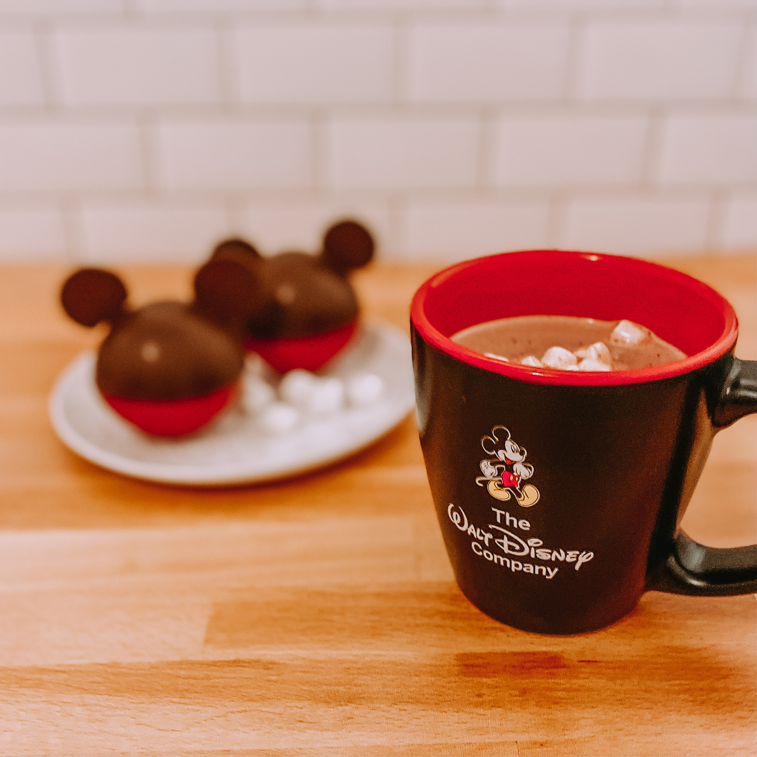 mickey mouse hot cocoa bombs with a mug of hot cocoa