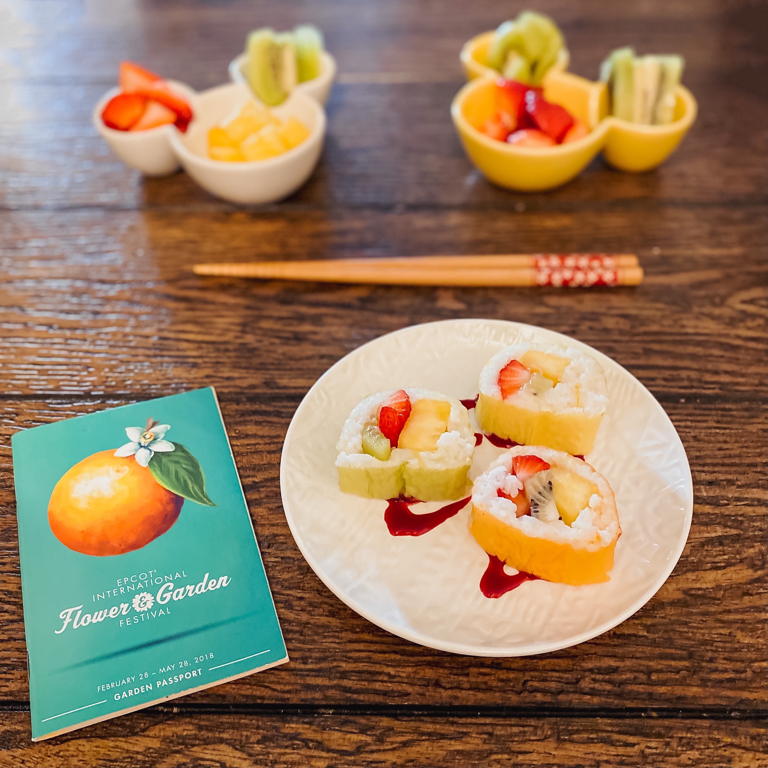 plate with frushi and two containers of fresh fruit