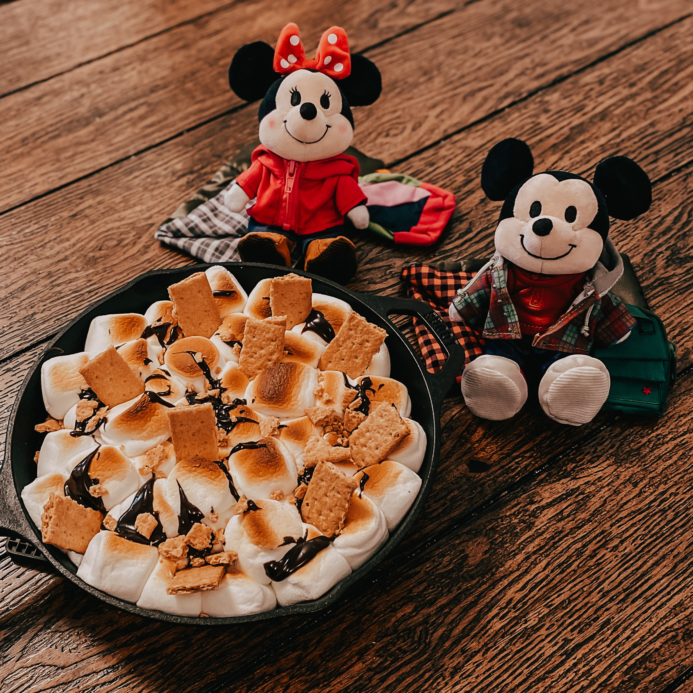 Mickey & Minnie's Campfire S'mores Bake in a cast iron skillet with Mickey and Minnie plushies