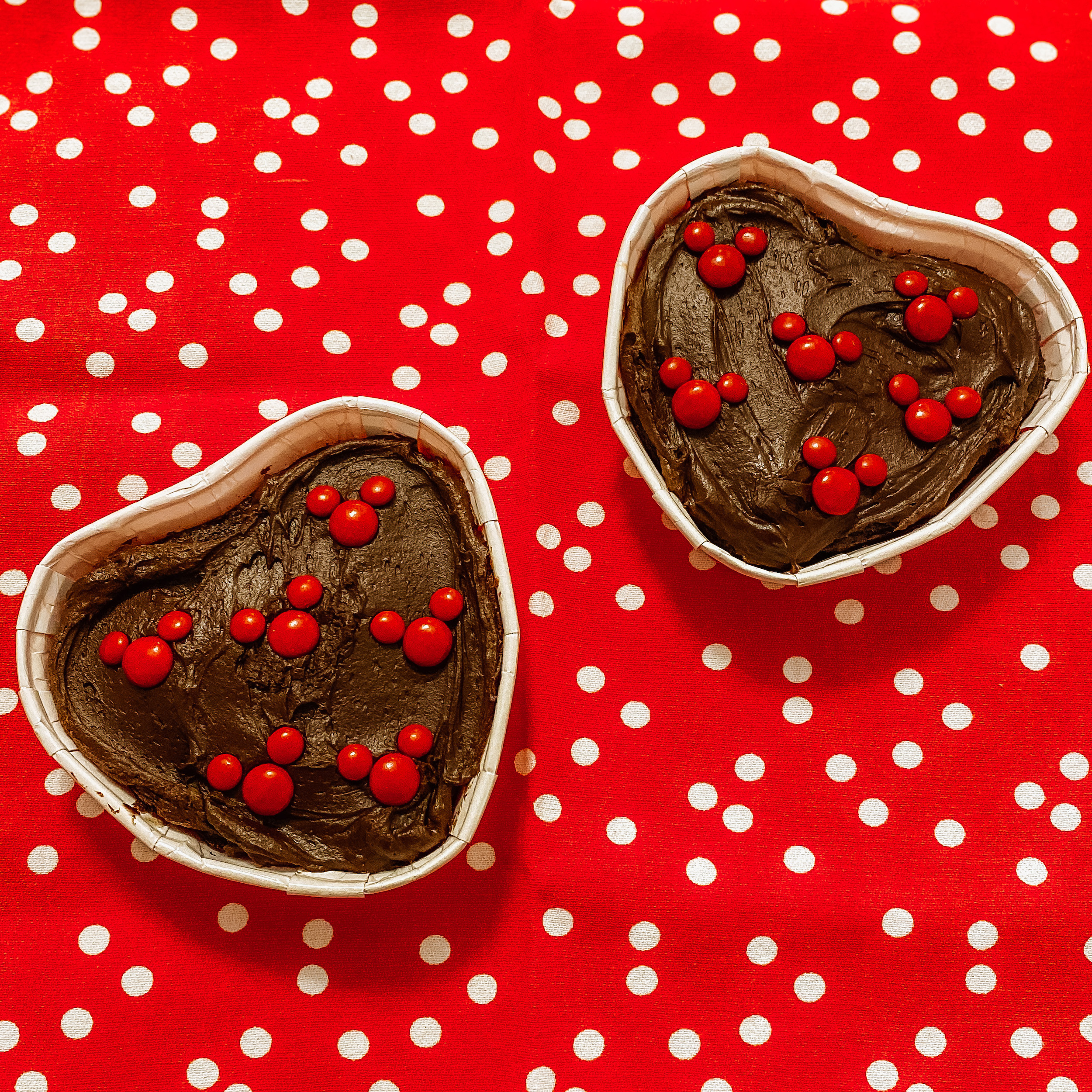 chocolate Mickey & Minnie's Sweetheat Brownies with red mickey shaped m&ms on a red and white polka dot background.