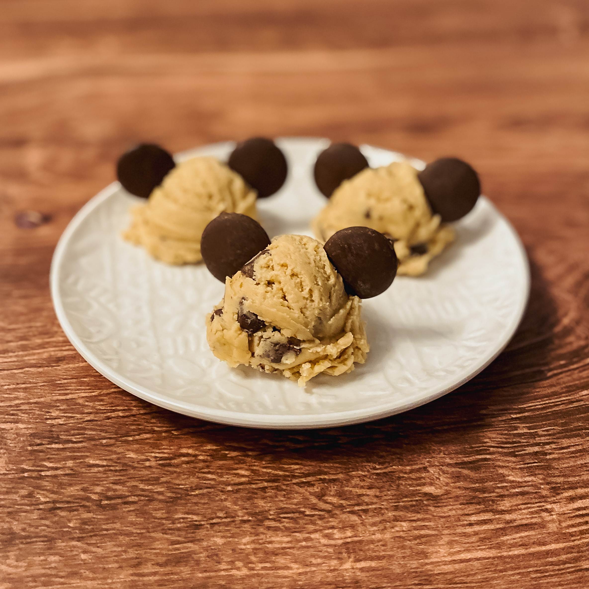 chocolate chip cookie dough bites on a plate with chocolate mickey ears