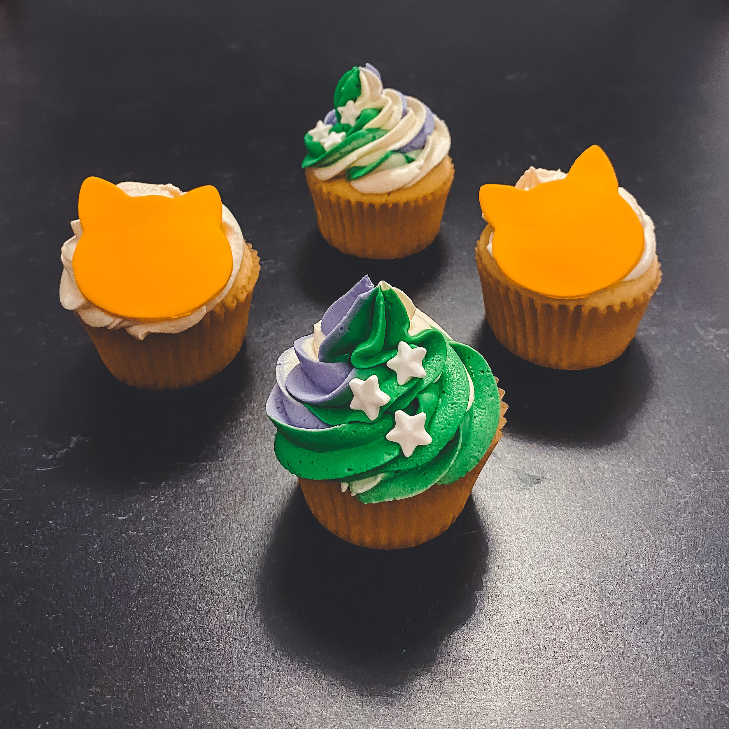 Lightyear Cupcakes (vanilla cupcakes with a swirl of green, purple, and white frosting with candy stars and vanilla cupcakes with white frosting and an orange fondant cat decoration)