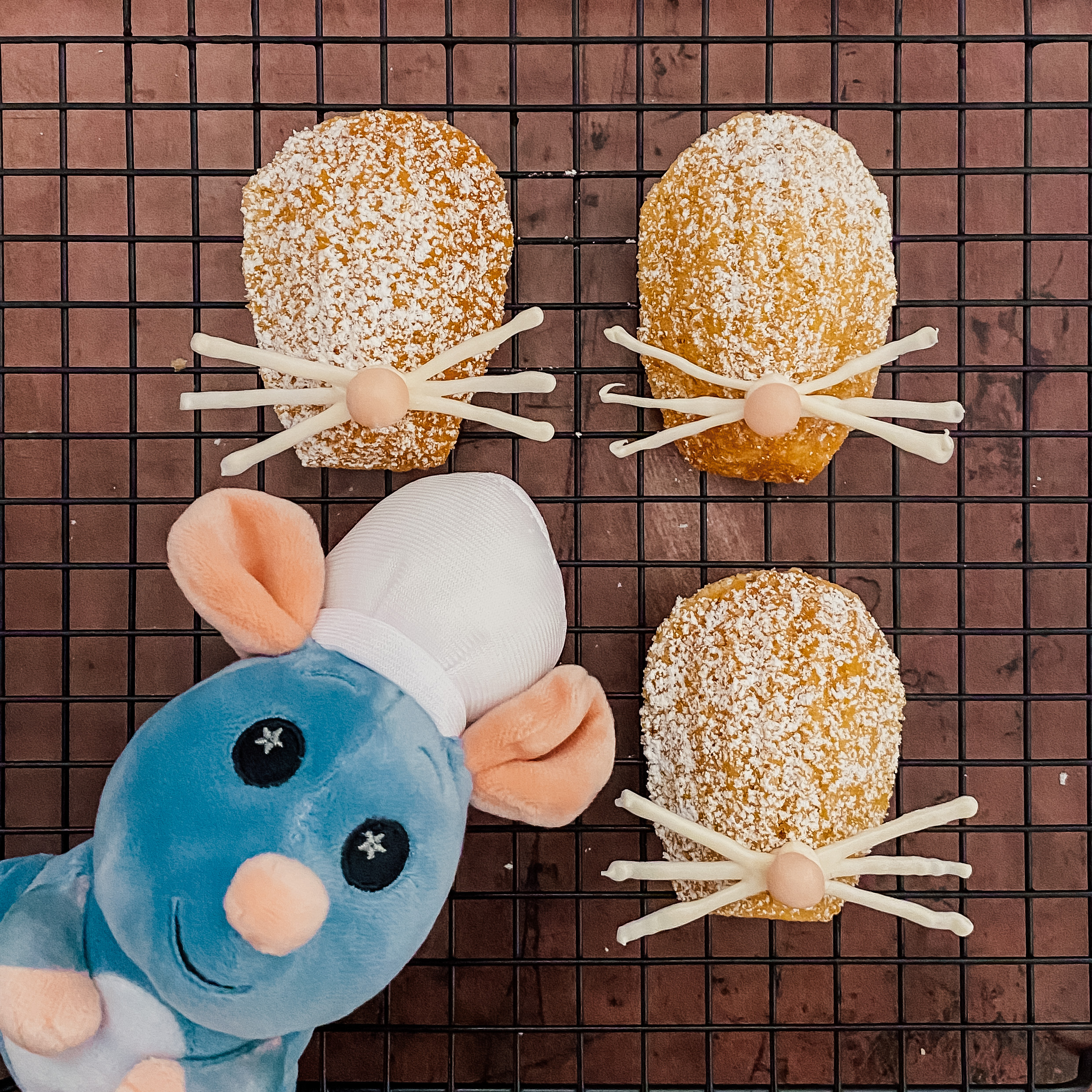Ratatouille Madeleines (4 lemon madeleines with powdered sugar, white chocolate whiskers and a pink fondant nose) with a Remy plushie