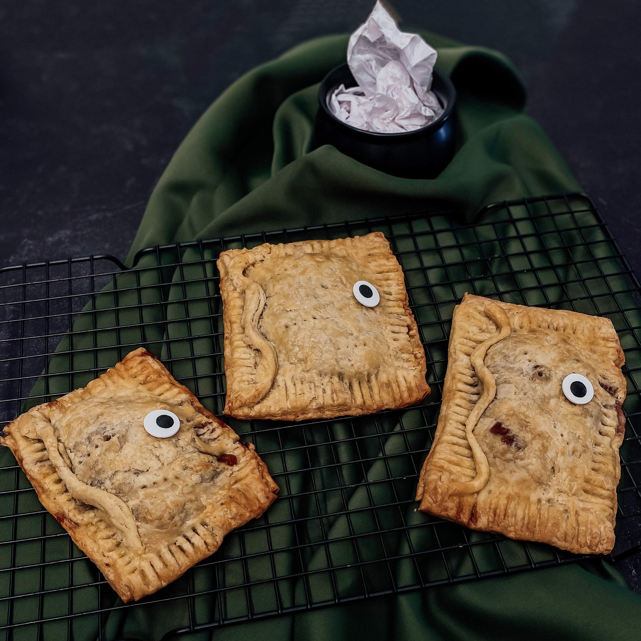 Winifred's Spellbook Hand Pies (three book shaped pies on a green background with a mini cauldron)