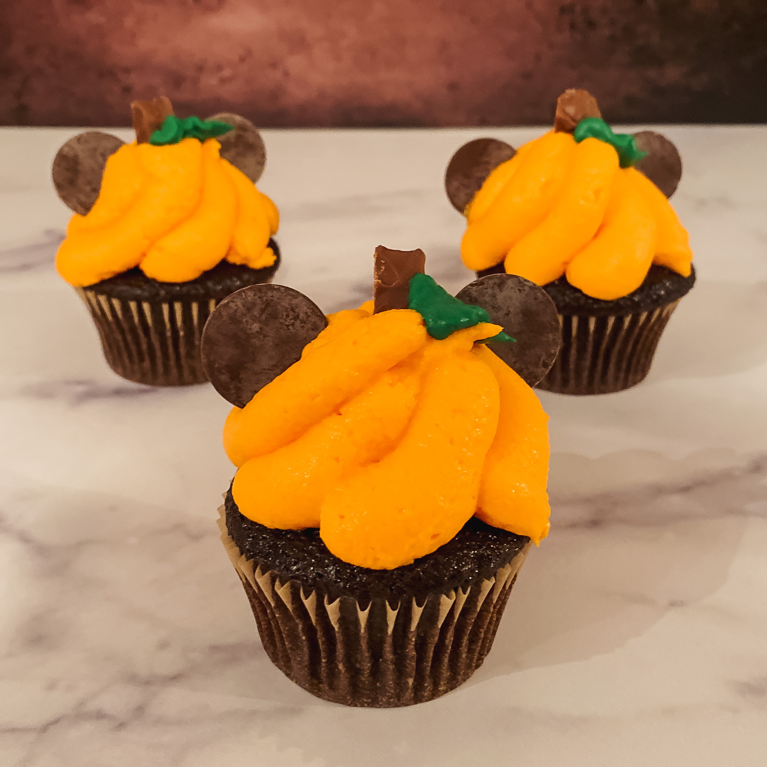 3 Pumpkin Patch Mickey Cupcakes (chocolate cupcakes with orange frosting and chocolate pieces)
