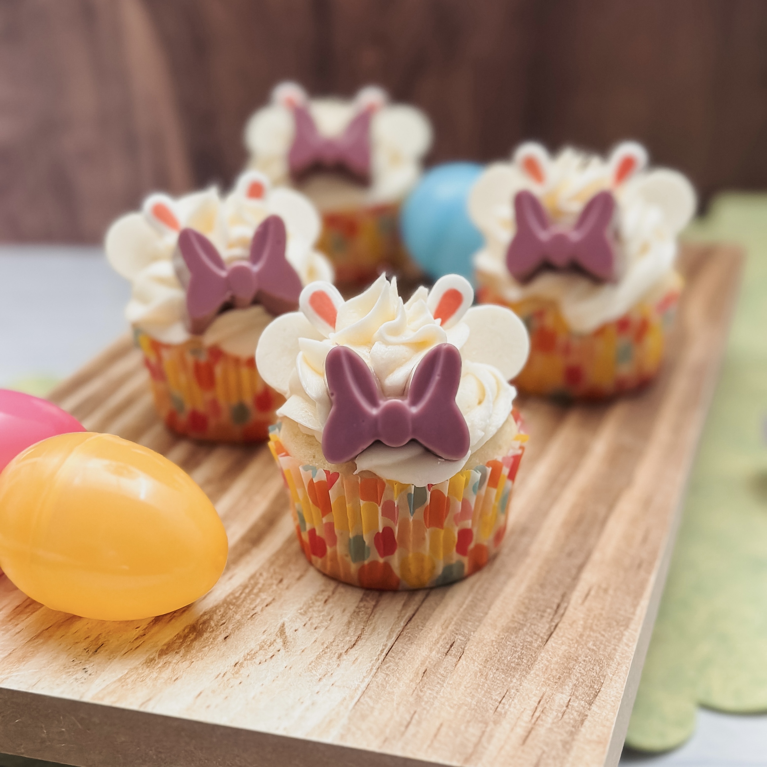 Minnie's Easter Bunny Cakes (vanilla cupcakes with white frosting, purple candy bow, minnie ears, and bunny ears)