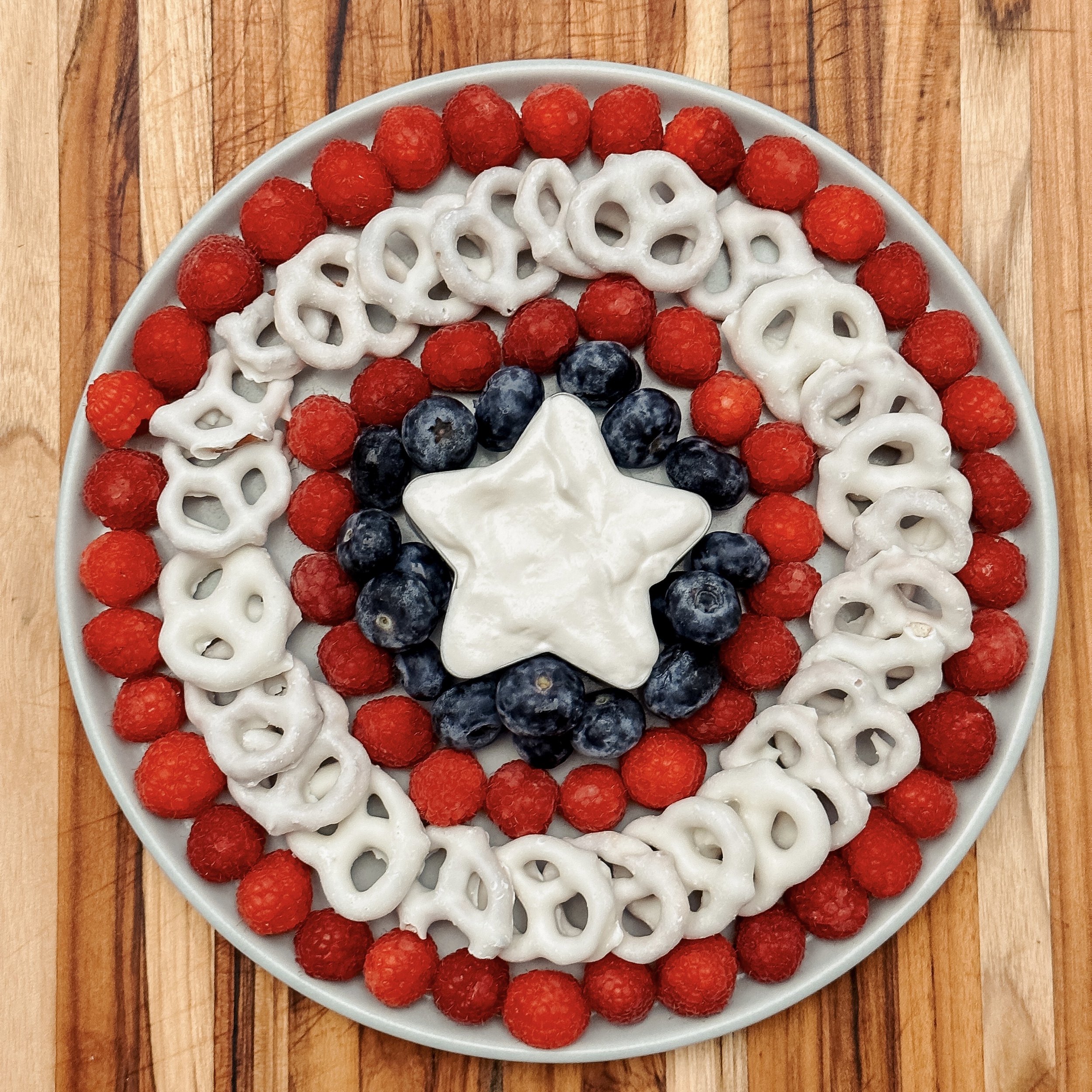 Captain America's Fruit Platter (round plate with raspberries, blueberries, and yogurt covered pretzels arranged like Captain America's shield)