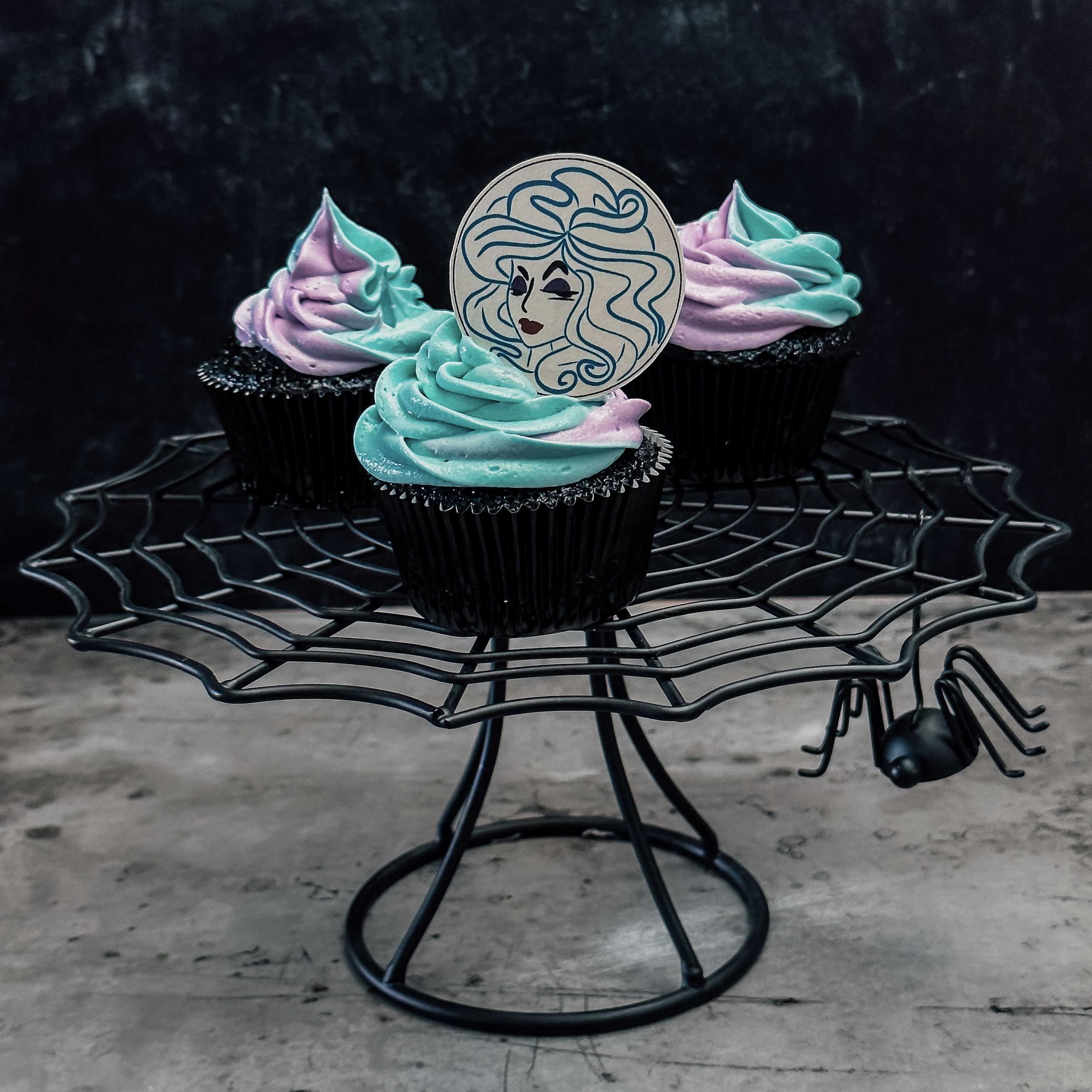 Madame Leota Cupcakes (three black chocolate cupcakes with a swirl of blue and purple frosting and a Madame Leota decoration)