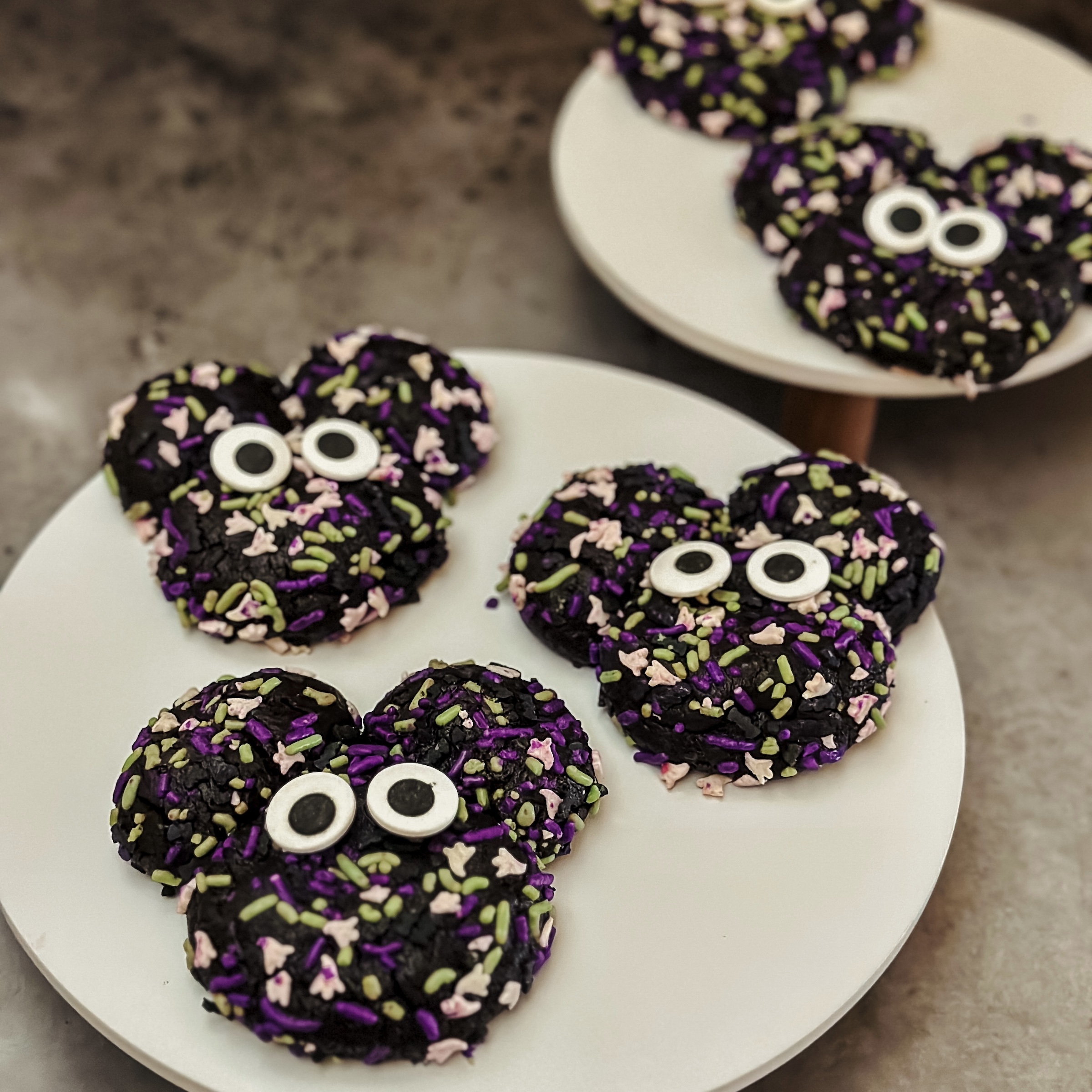 Spooky Mickey Cookies (three chocolate crinkle cookies with halloween sprinkles on a cake)
