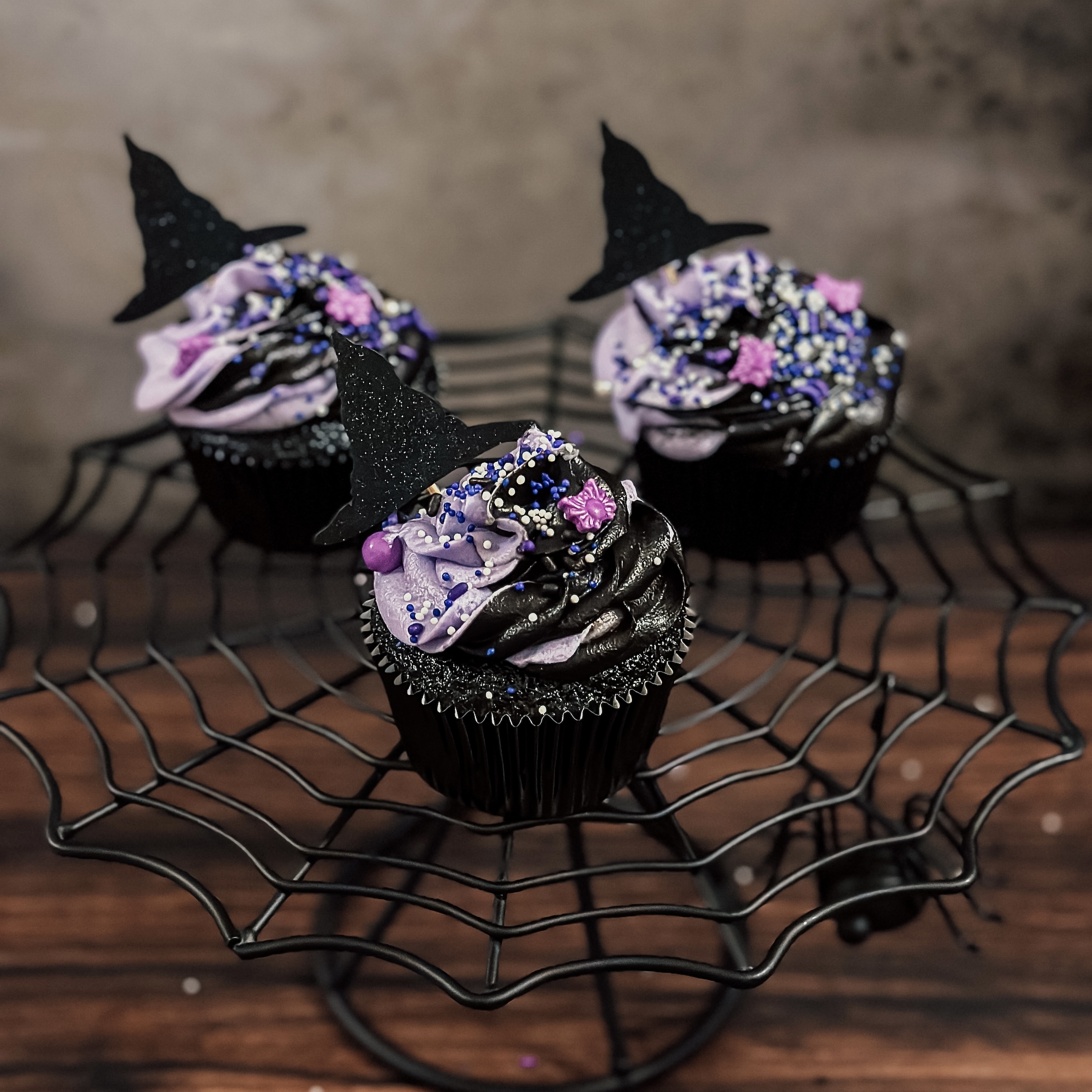 Agatha's Chocolate All Along Cupcakes (black chocolate cupcakes with purple and black frosting swirl, sprinkles, and a witch hat topper)